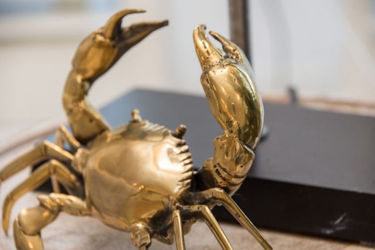 Shelving Units - a golden crab statue sitting on top of a table