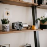 Corner Shelves - a shelf with a camera and a potted plant