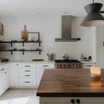 Open Shelving - a kitchen with a wooden counter top next to a stove top oven