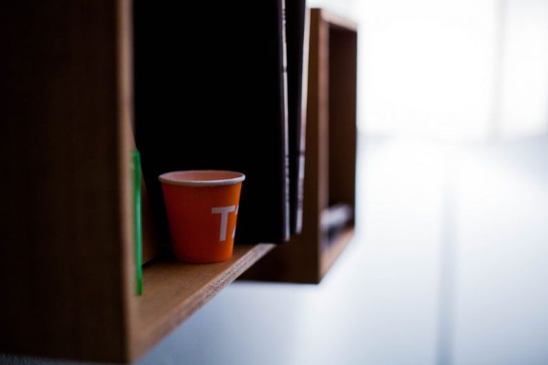 Shelving Solutions - red disposable cup on brown wooden shelf
